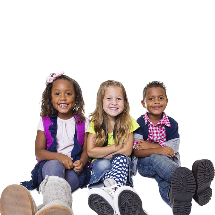 Three children smiling sitting on floor with legs out and arms crossed