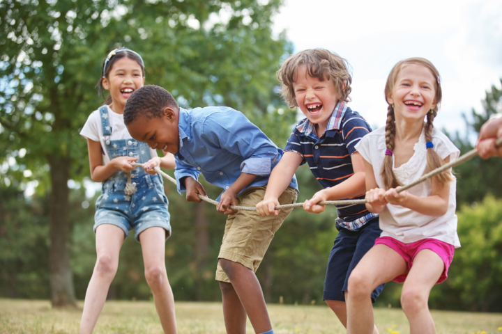 children playing tug of war in the summer